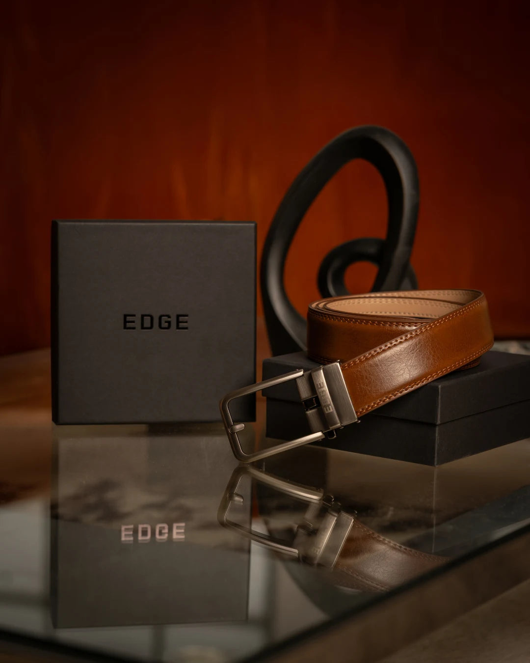 Braon EDGE kaiš na crnoj poklon kutiji EDGE ispred narandžastog zida