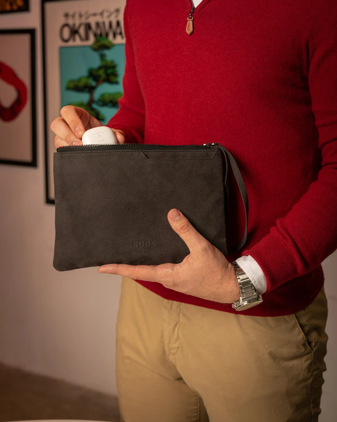 Tamnosiva torbica za ruku EDGE sa patent zatvaračem i kaišem, u rukama muškarca